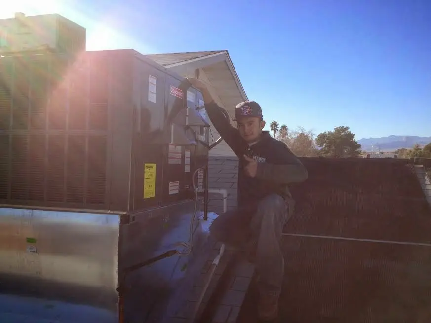 HVAC technician performing AC Tune-Up on a rooftop unit in Sauk Rapids