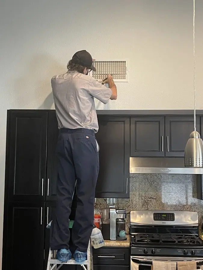 Technician inspecting an air vent during HVAC service in Sauk Rapids